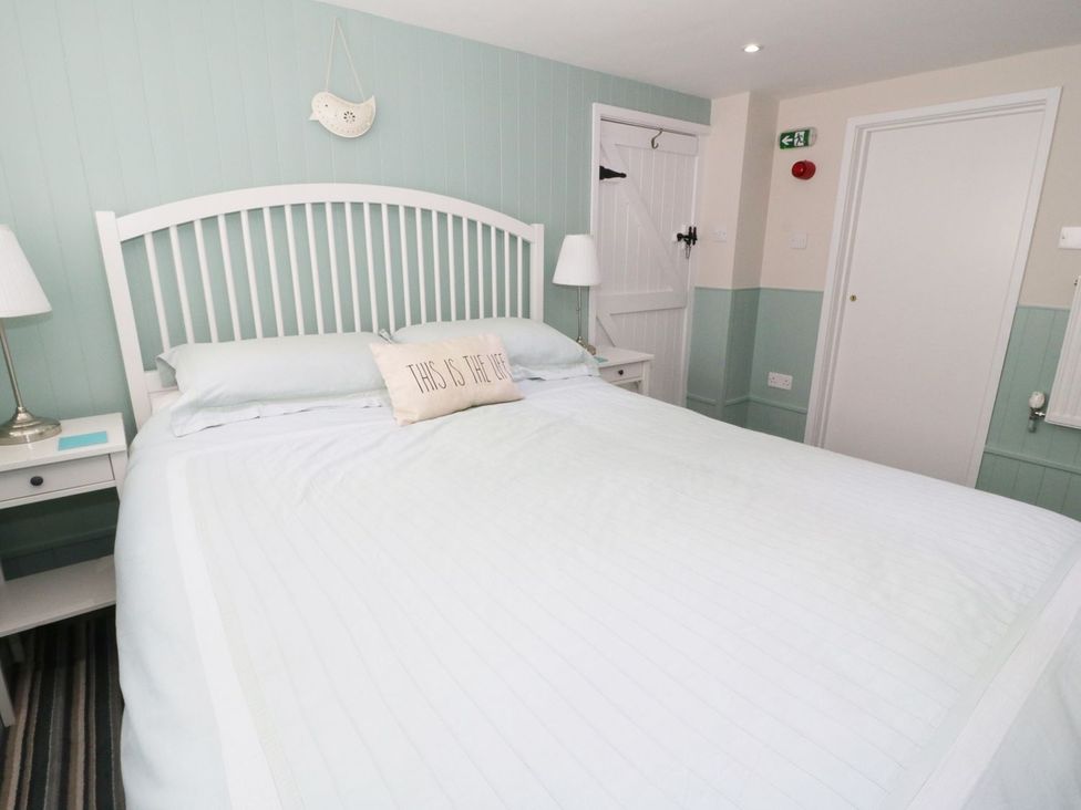 A bedroom with a bed and bedside tables at The Hideaways Tyn-y-Gongl