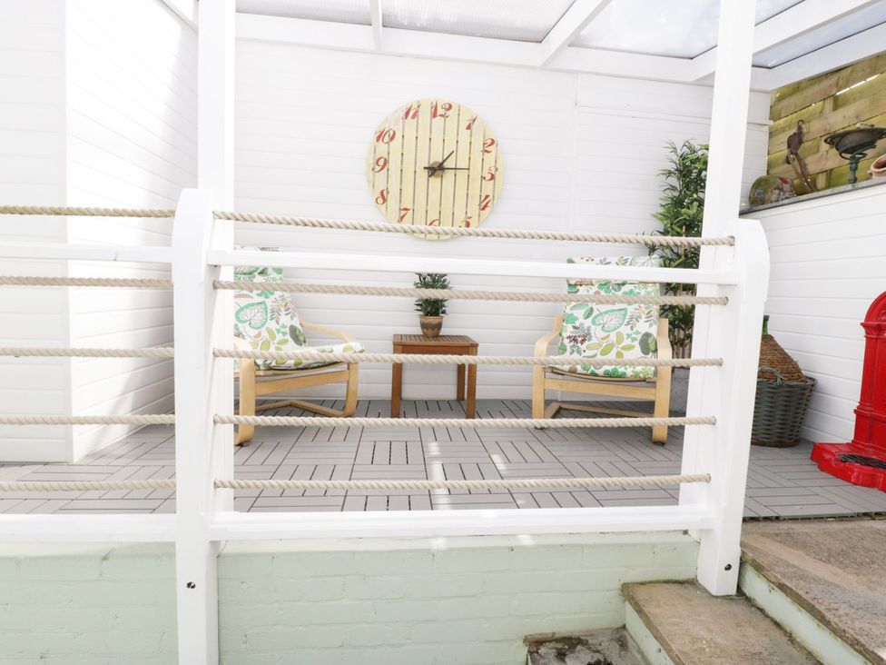 An outdoor area with chairs and a table at The Hideaways in Tyn-y-Gongl