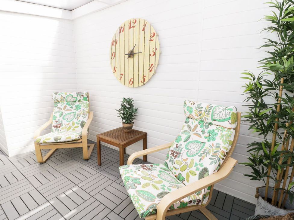 A snug with armchairs and a small table at The Hideaways in Tyn-y-Gongl