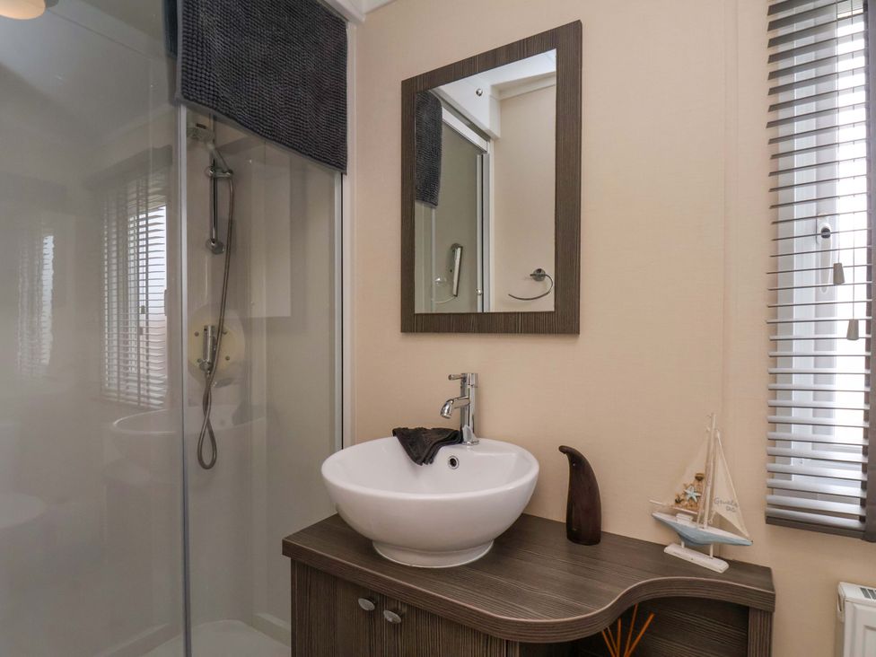 A bathroom with a shower, sink, and mirror at Finch 66 in Scarborough