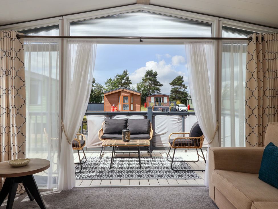 A living room with patio doors leading to a deck at Lodge - Plot 18 near Sherburn
