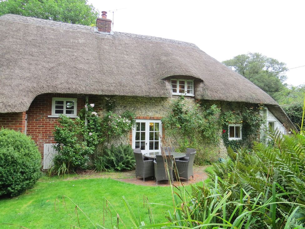A cottage with a thatched roof and garden at Little Owl High Cross near Petersfield