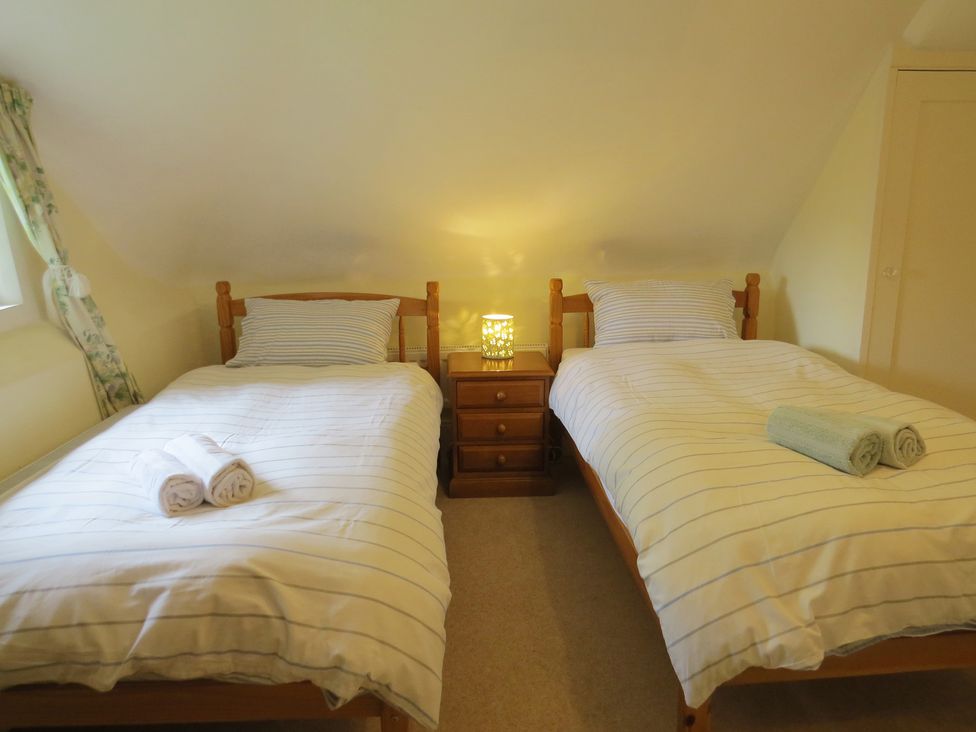 A bedroom with two beds and a bedside table at Little Owl in High Cross near Petersfield
