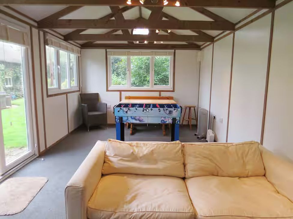 A snug with a foosball table and sofa at Little Owl in High Cross near Petersfield