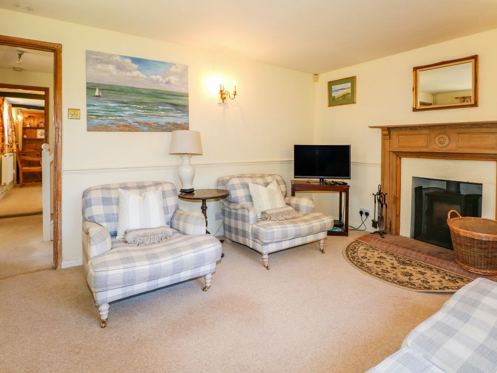 A living room with armchairs and a television at Little Owl in High Cross near Petersfield