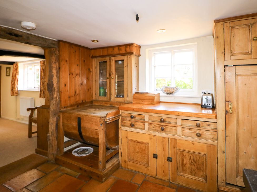A kitchen with wooden cabinets and a sink at Little Owl High Cross near Petersfield