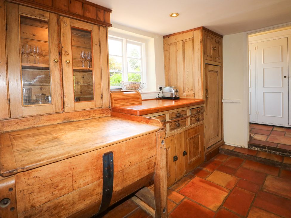 A kitchen with wooden cupboards and a toaster at Little Owl in High Cross near Petersfield