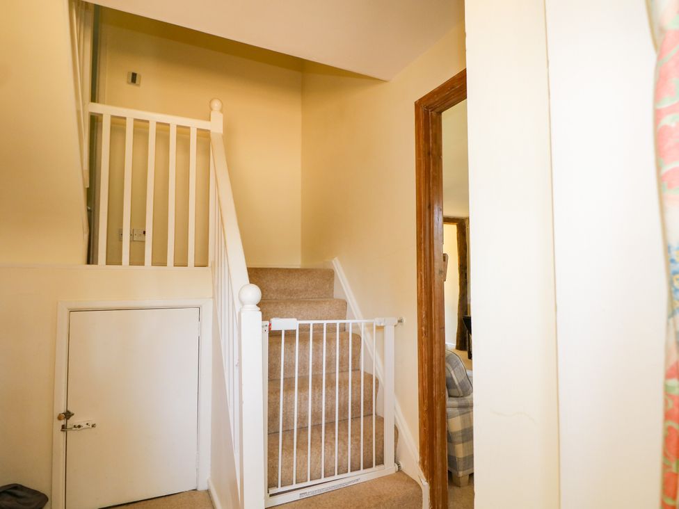 A staircase with a safety gate in a hallway at Little Owl in High Cross near Petersfield