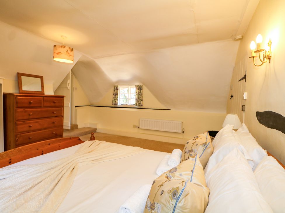 A bedroom with a bed and a dresser at Little Owl High Cross near Petersfield