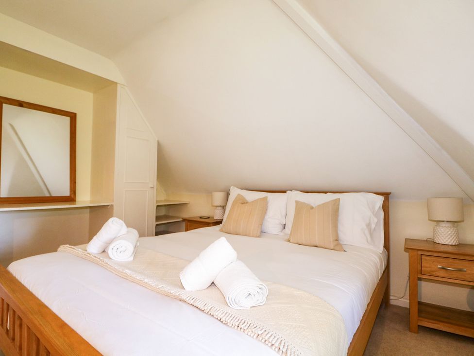 A bedroom with a bed and bedside tables at Little Owl in High Cross near Petersfield