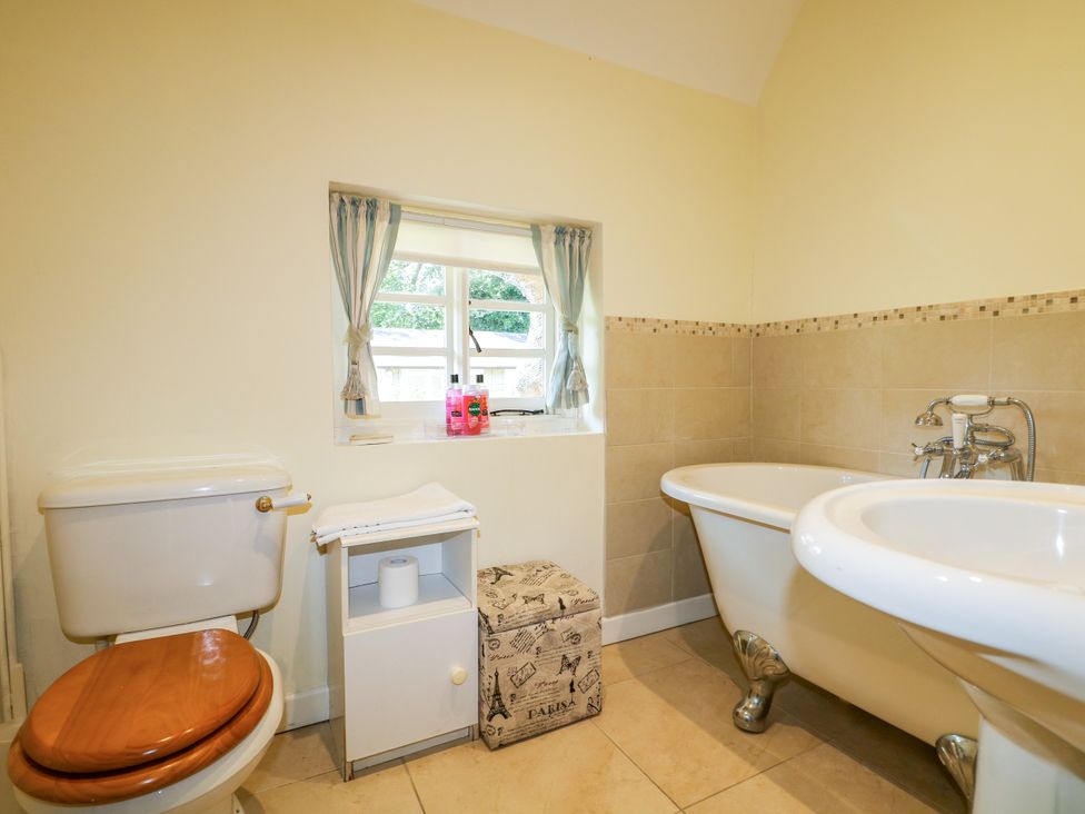 A bathroom with a bathtub and a toilet at Little Owl High Cross near Petersfield