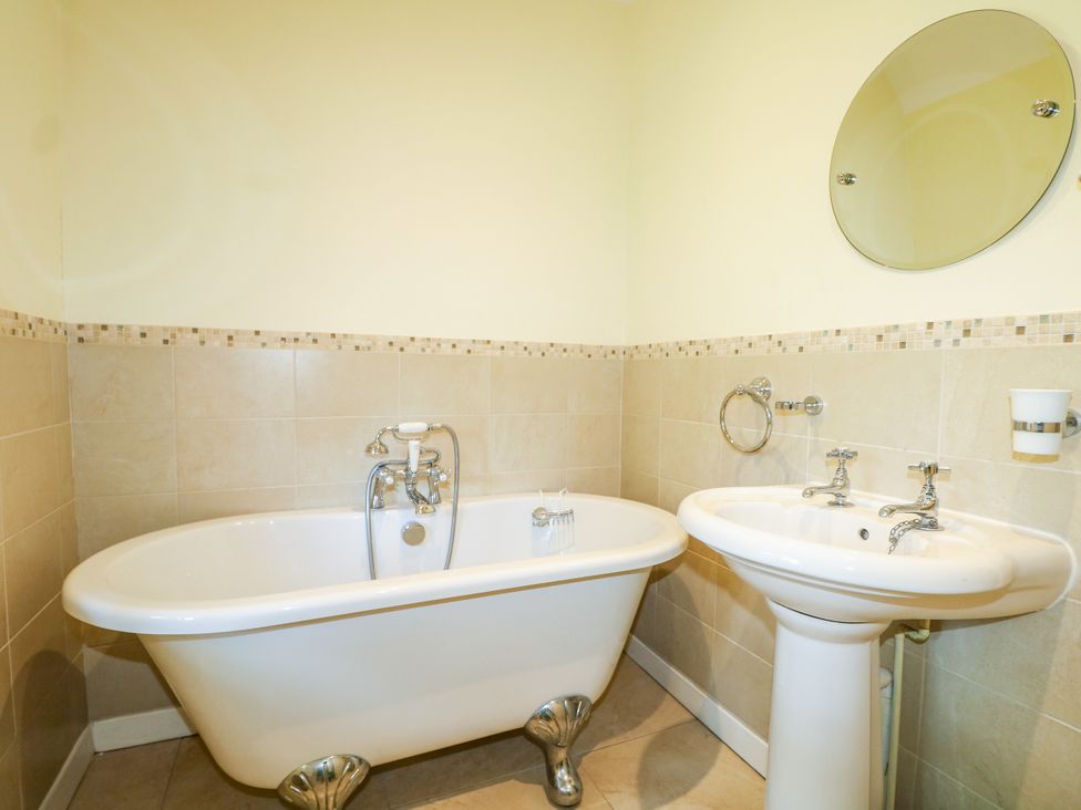 A bathroom with a bathtub and wash basin at Little Owl in High Cross near Petersfield