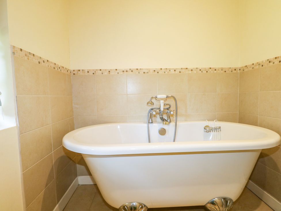 A bathroom with a bathtub and faucet at Little Owl in High Cross near Petersfield