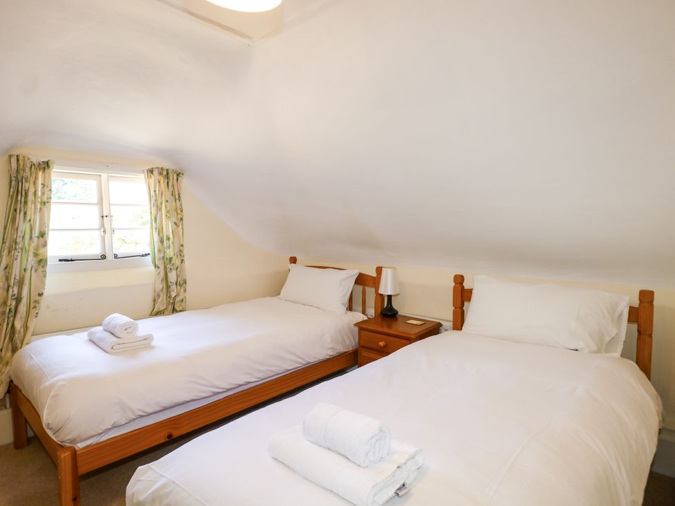A bedroom with two beds and a bedside table at Little Owl in High Cross near Petersfield