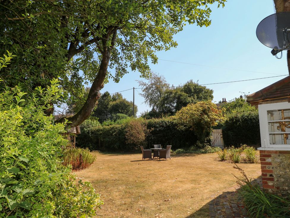 A garden with a table and chairs at Little Owl in High Cross near Petersfield