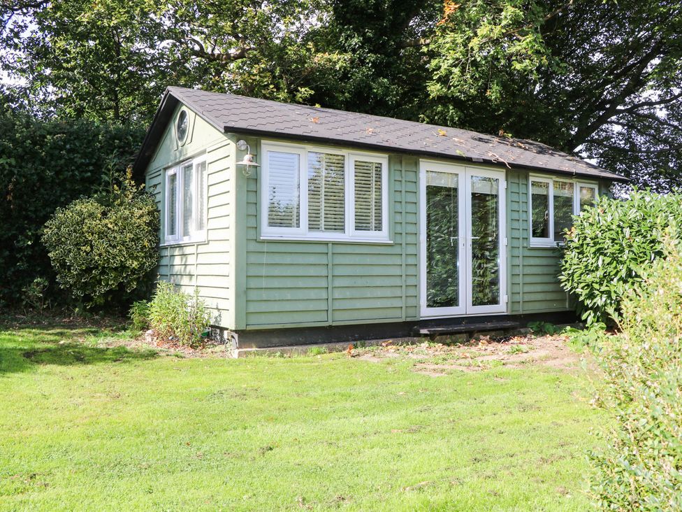 A cabin with windows and a door at Little Owl High Cross near Petersfield