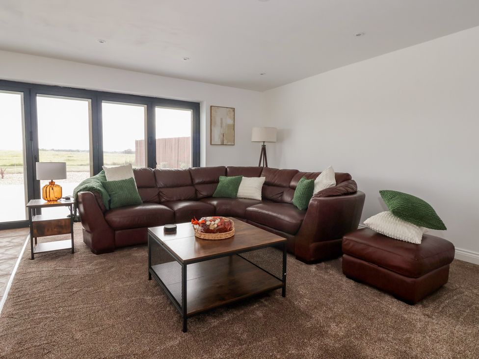 A living room with a corner sofa and coffee table at Gravel Pit Cottage in Bridlington