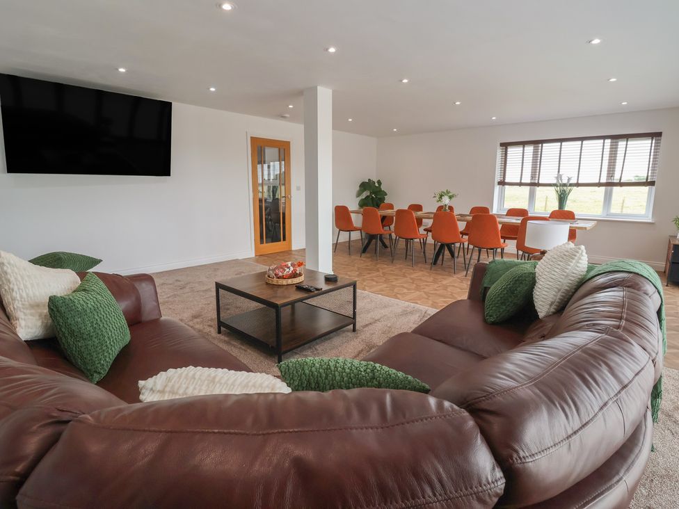 A living room with a sofa and dining table at Gravel Pit Cottage in Bridlington