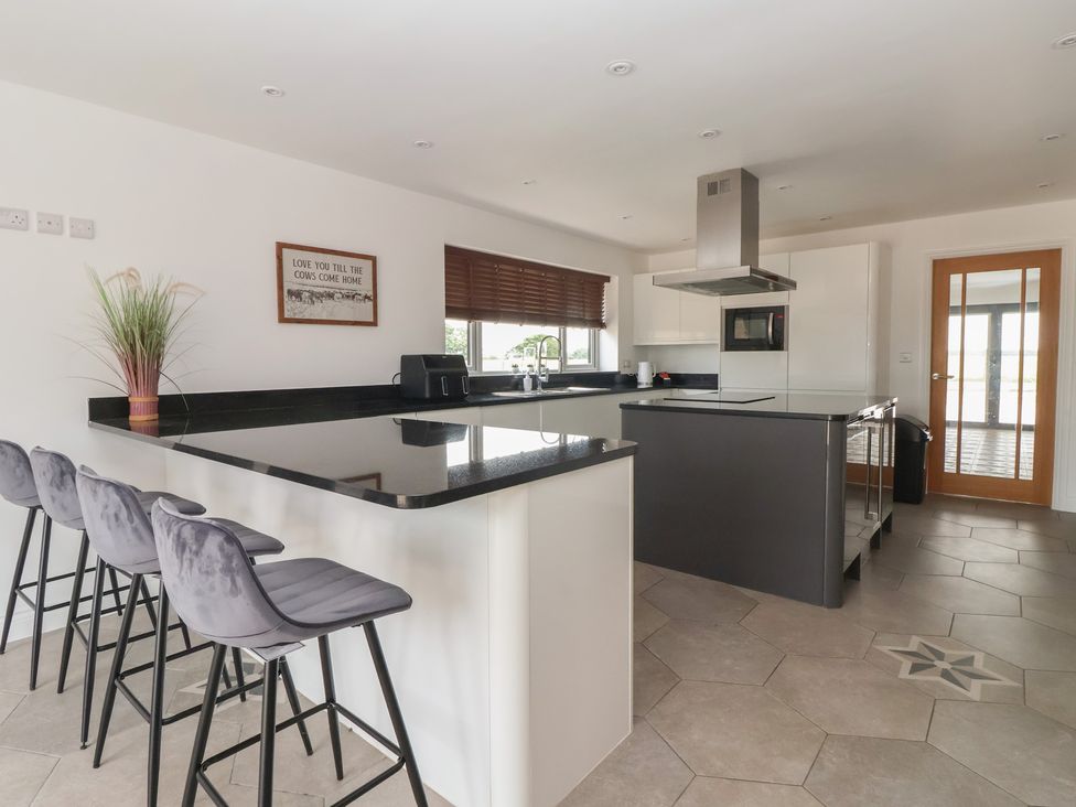 A kitchen with bar stools and a countertop at Gravel Pit Cottage in Bridlington
