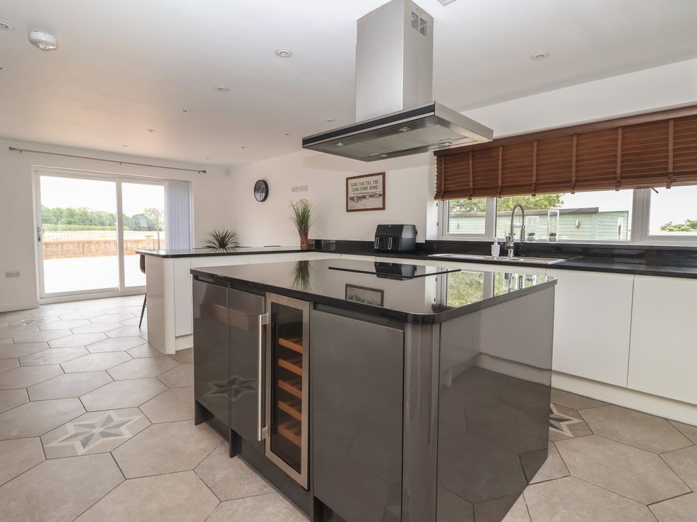 A kitchen with an island, sink, and cooker hood at Gravel Pit Cottage in Bridlington