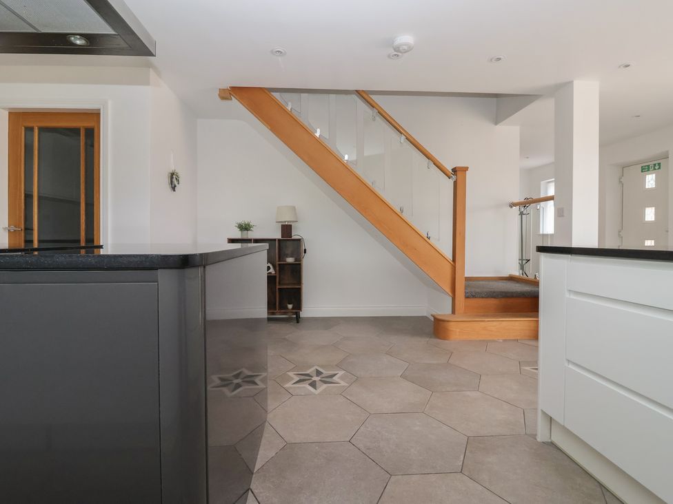 A kitchen with a staircase and kitchen island at Gravel Pit Cottage in Bridlington