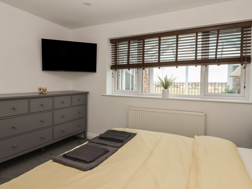 A bedroom with a television and dresser at Gravel Pit Cottage in Bridlington