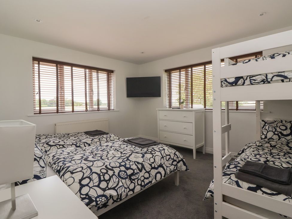 A bedroom with a bunk bed and a dresser at Gravel Pit Cottage in Bridlington