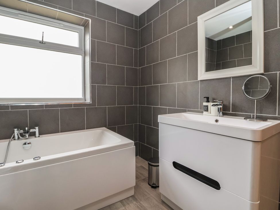 A bathroom with a bathtub and washbasin at Gravel Pit Cottage in Bridlington