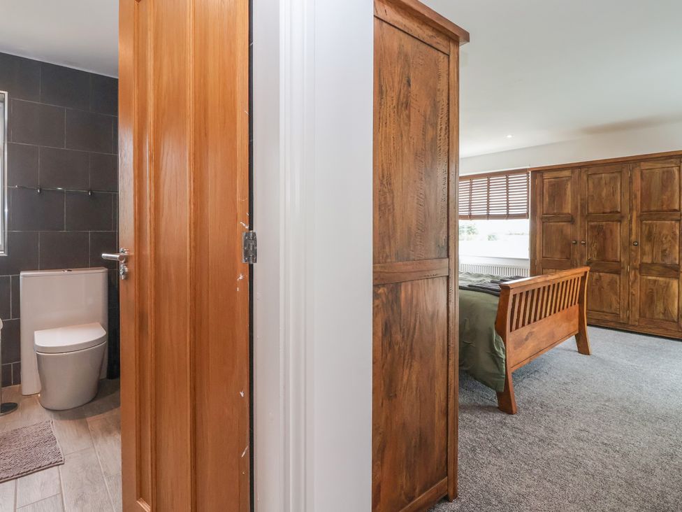 A bedroom with a bed and wardrobe at Gravel Pit Cottage in Bridlington