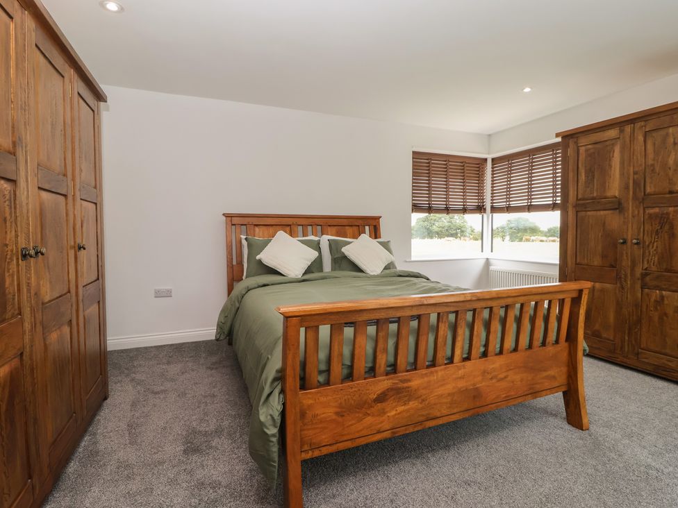 A bedroom with a bed and wardrobes at Gravel Pit Cottage in Bridlington