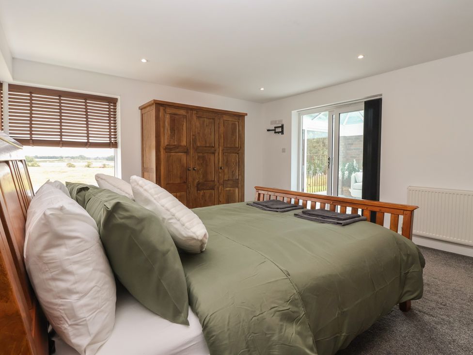 A bedroom with a bed and cabinet at Gravel Pit Cottage in Bridlington