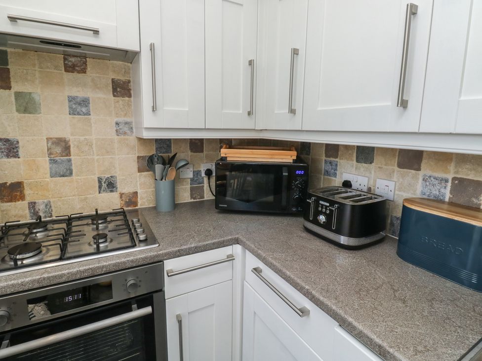 A kitchen with a gas stove, microwave, and toaster at 15D Foss Street, Dartmouth