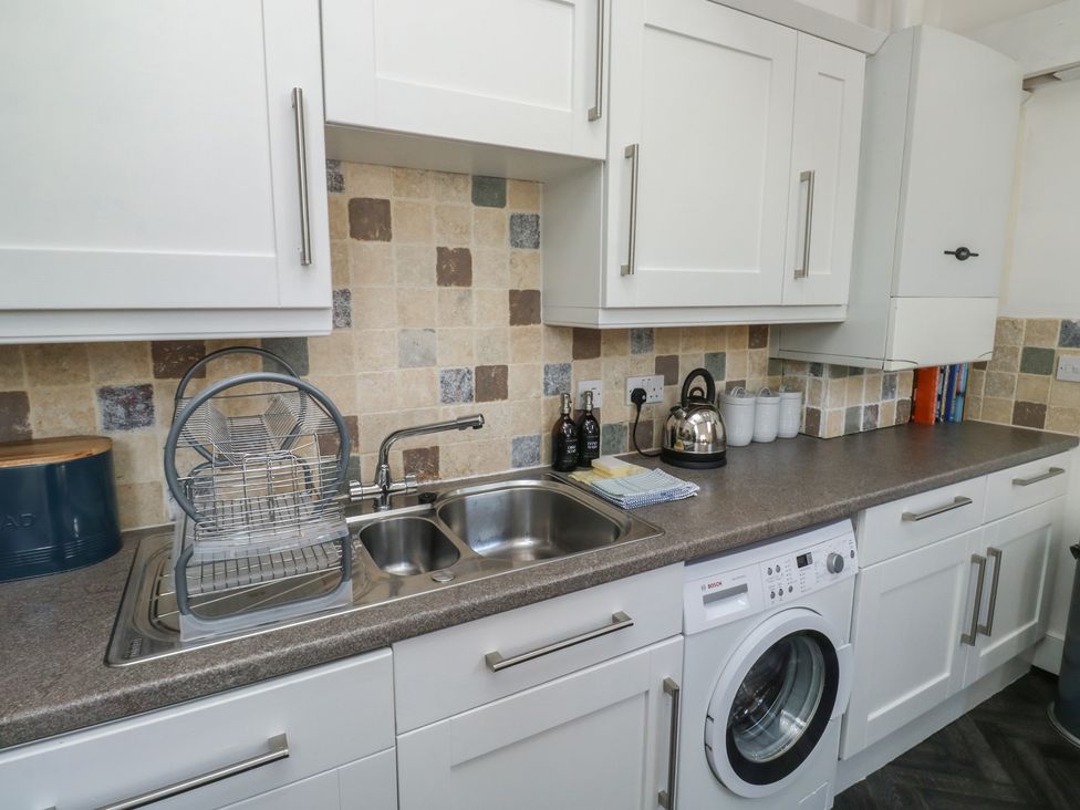 A kitchen with a sink and washing machine at 15D Foss Street in Dartmouth