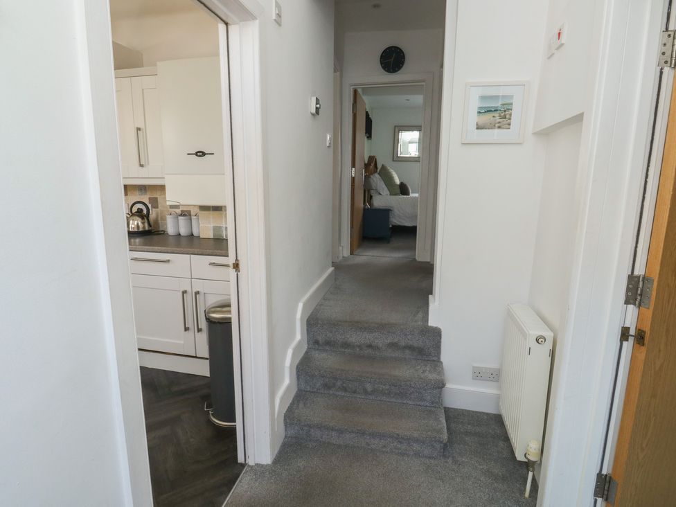 A hallway with a staircase and kitchen view at 15D Foss Street in Dartmouth