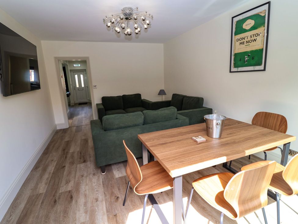 A living room with a sofa, table, and chairs at 2 Rookery Close, Nantwich