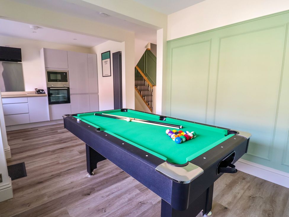 A game room with a pool table and kitchen area at 2 Rookery Close Nantwich