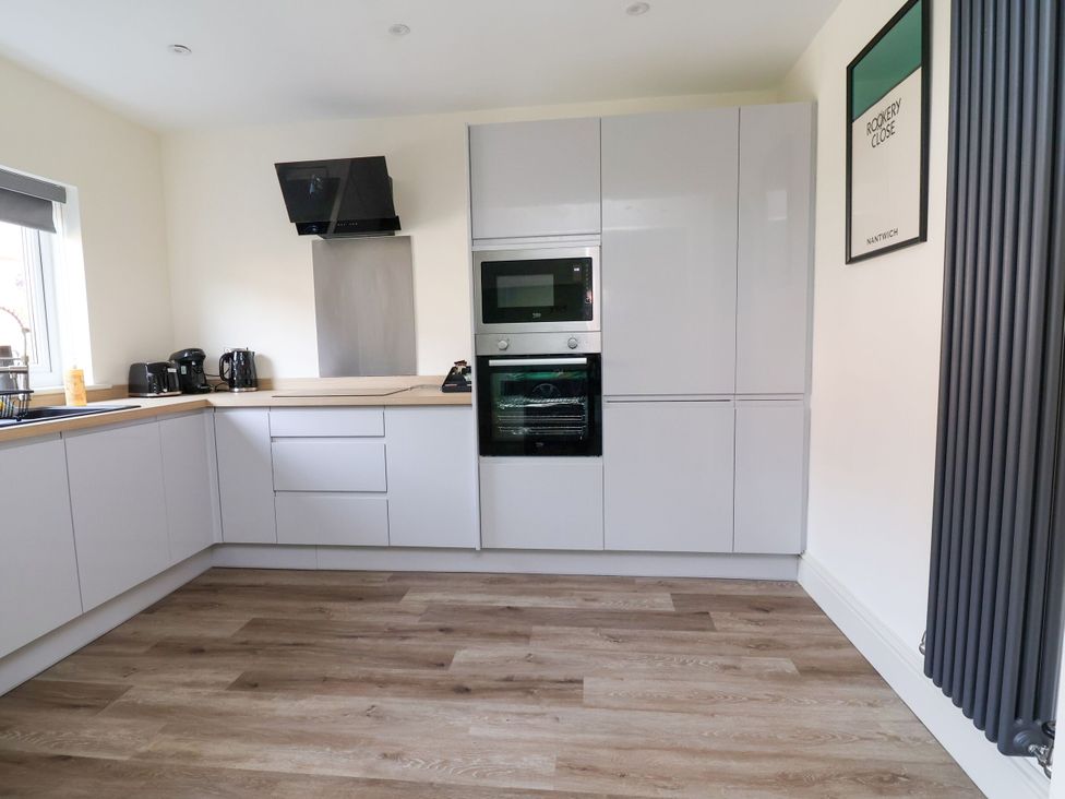 A kitchen with cabinets, sink, oven, and appliances at 2 Rookery Close Nantwich