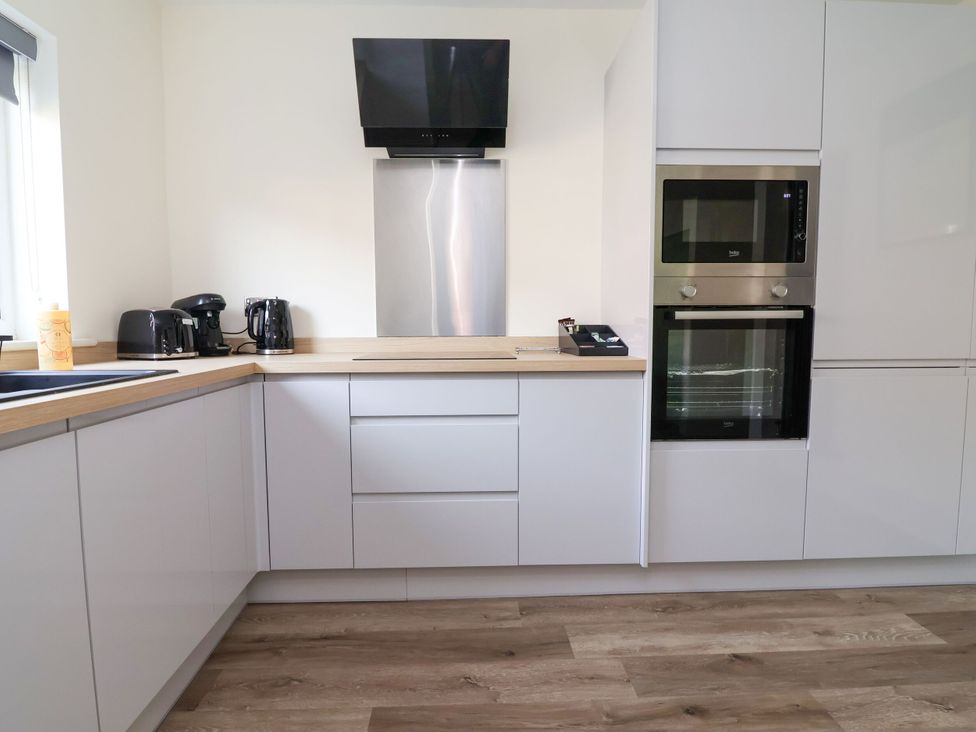A kitchen with appliances and countertops at 2 Rookery Close in Nantwich