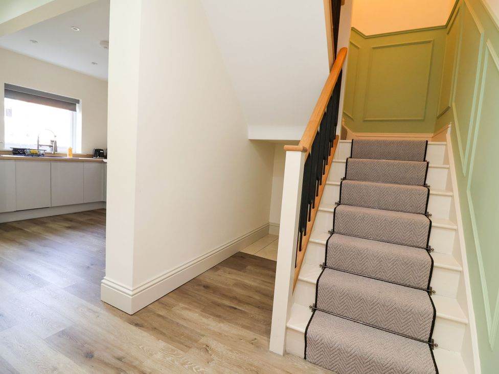 A hallway with a staircase and kitchen in view at 2 Rookery Close Nantwich