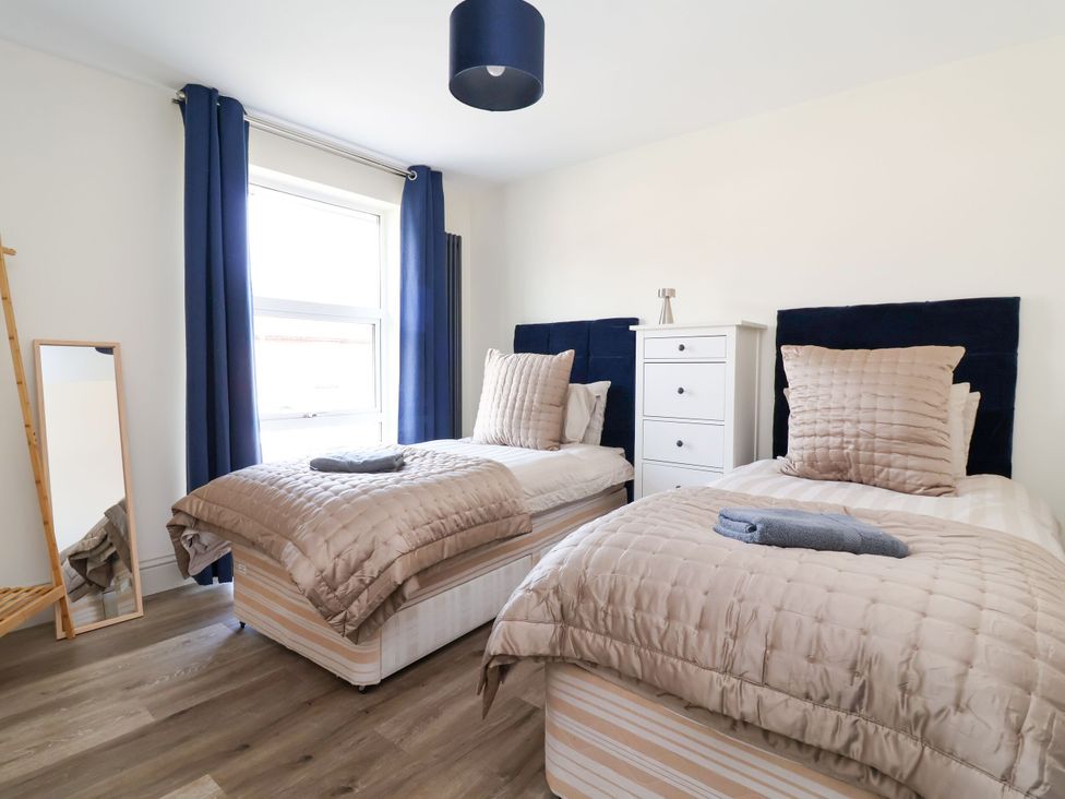 A bedroom with two beds and a dresser at 2 Rookery Close Nantwich