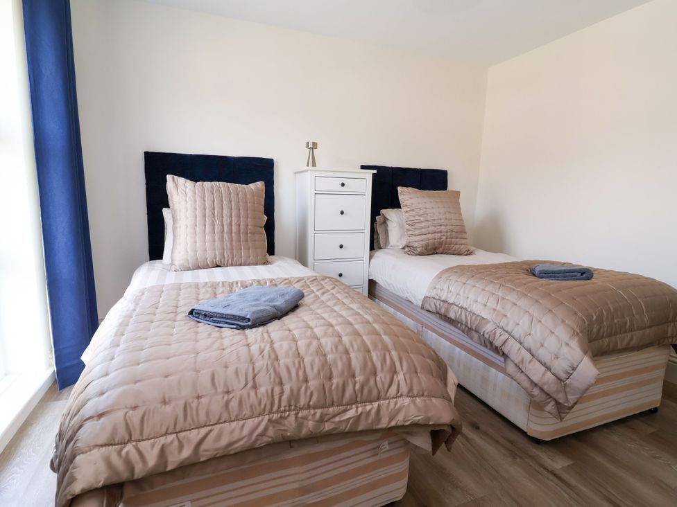 A bedroom with two single beds and a drawer chest at 2 Rookery Close Nantwich