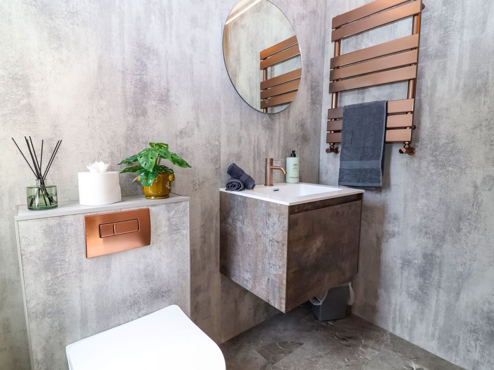 A bathroom with a sink, toilet, and towel rack at 2 Rookery Close Nantwich