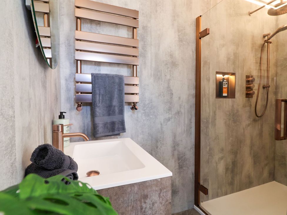 A bathroom with a sink, towel rack, and shower at 2 Rookery Close, Nantwich