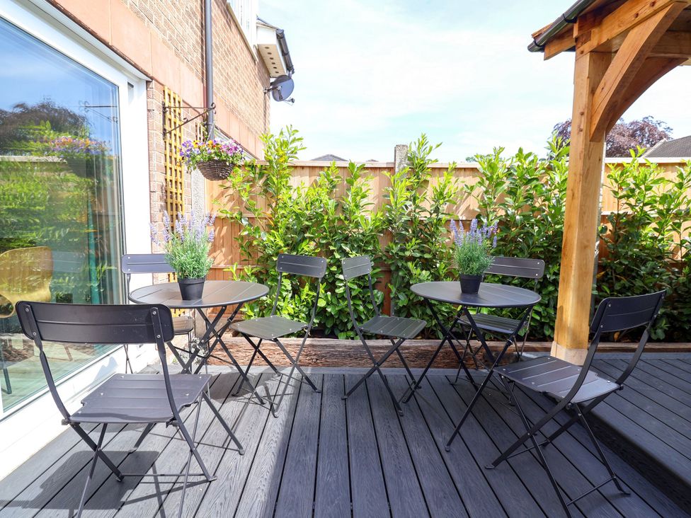 An outdoor seating area with black tables and chairs at 2 Rookery Close Nantwich