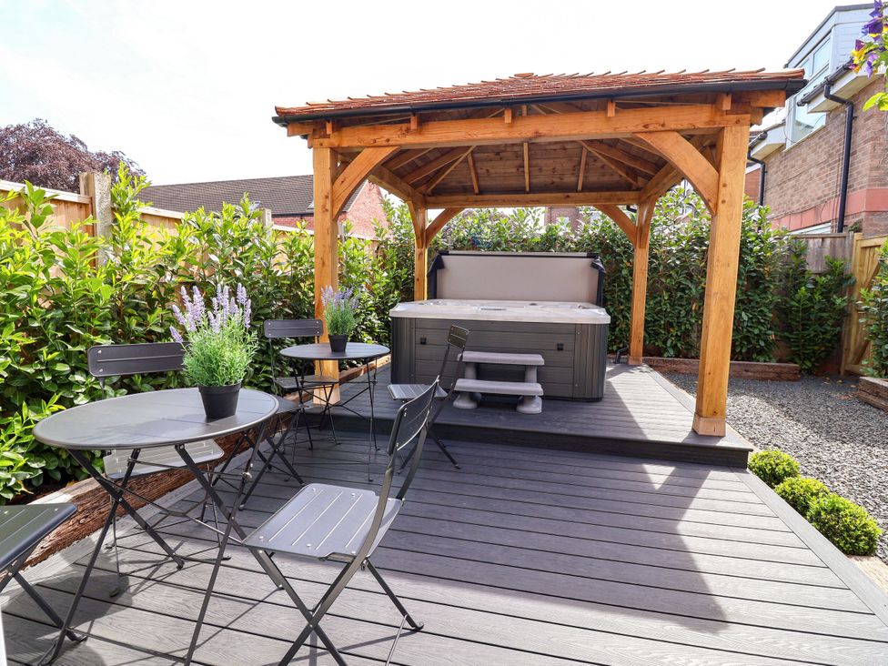 A garden with a gazebo and hot tub at 2 Rookery Close in Nantwich