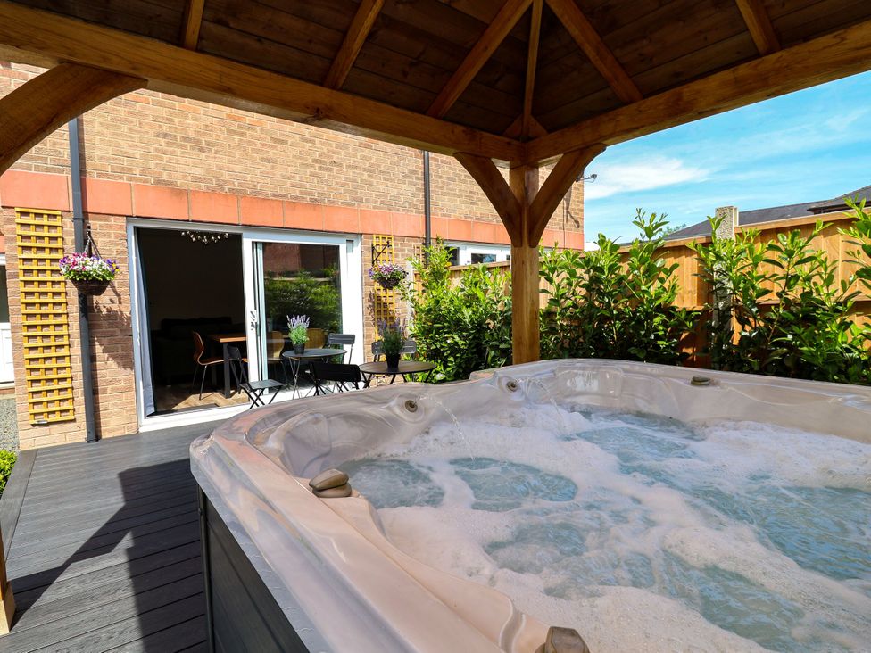 An outdoor area with a hot tub and seating at 2 Rookery Close in Nantwich