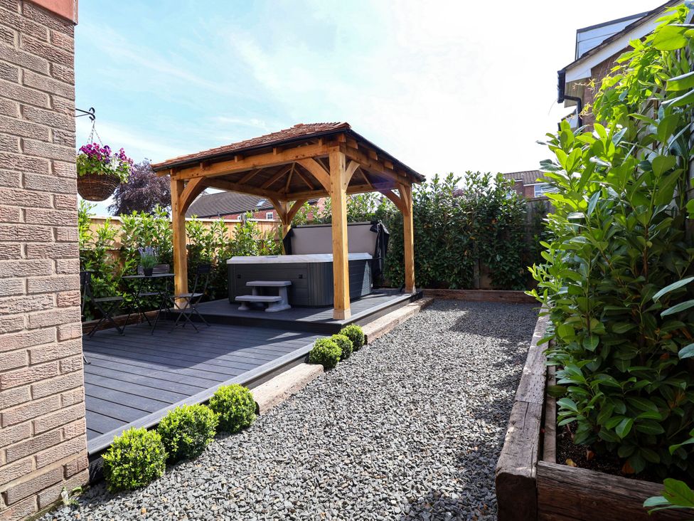 A garden with a gazebo and hot tub at 2 Rookery Close in Nantwich