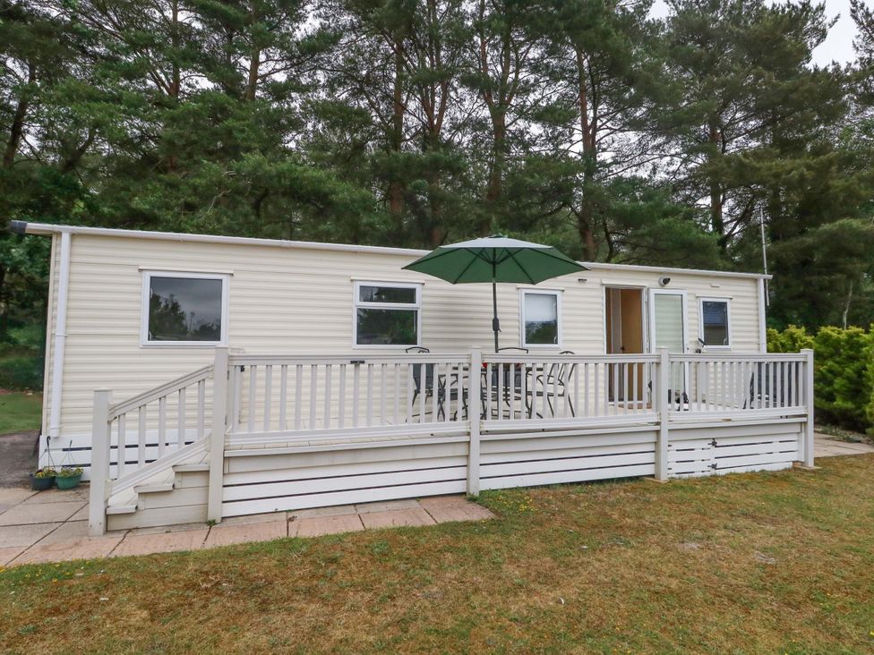 A mobile home with a deck and table at Foxglove 4 Ringwood