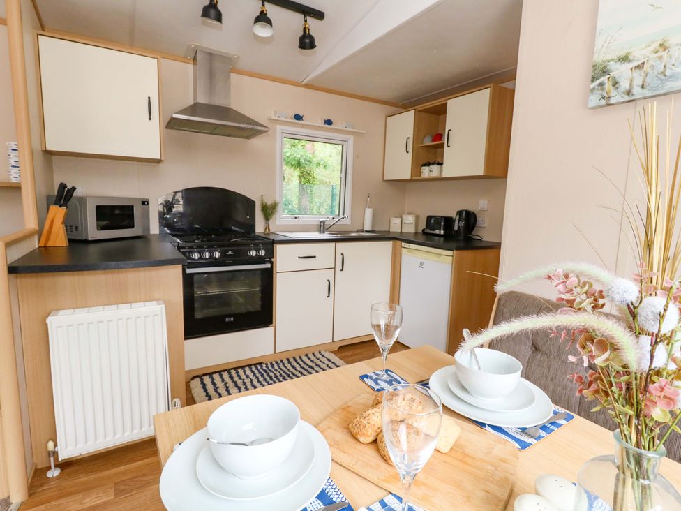 A kitchen with cooking appliances and dining setup at Foxglove 4 in Ringwood