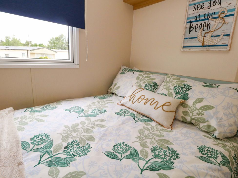 A bedroom with a bed and decorative pillows at Foxglove 4 in Ringwood